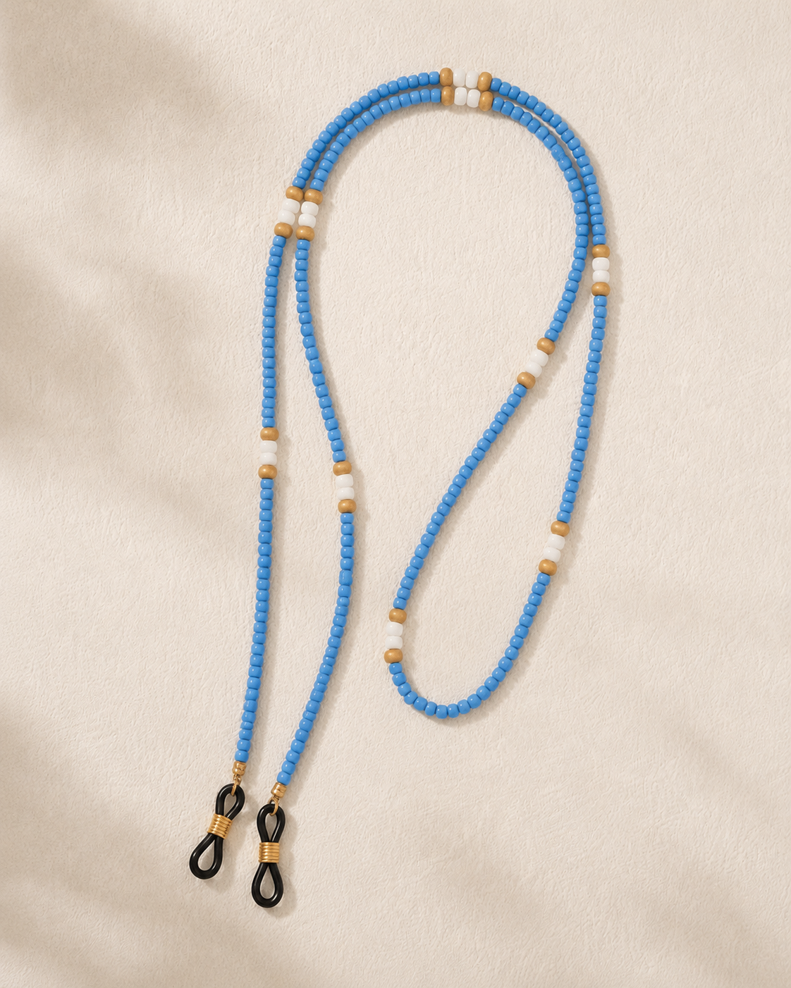 Blue beaded lanyard with black clip on a beige background